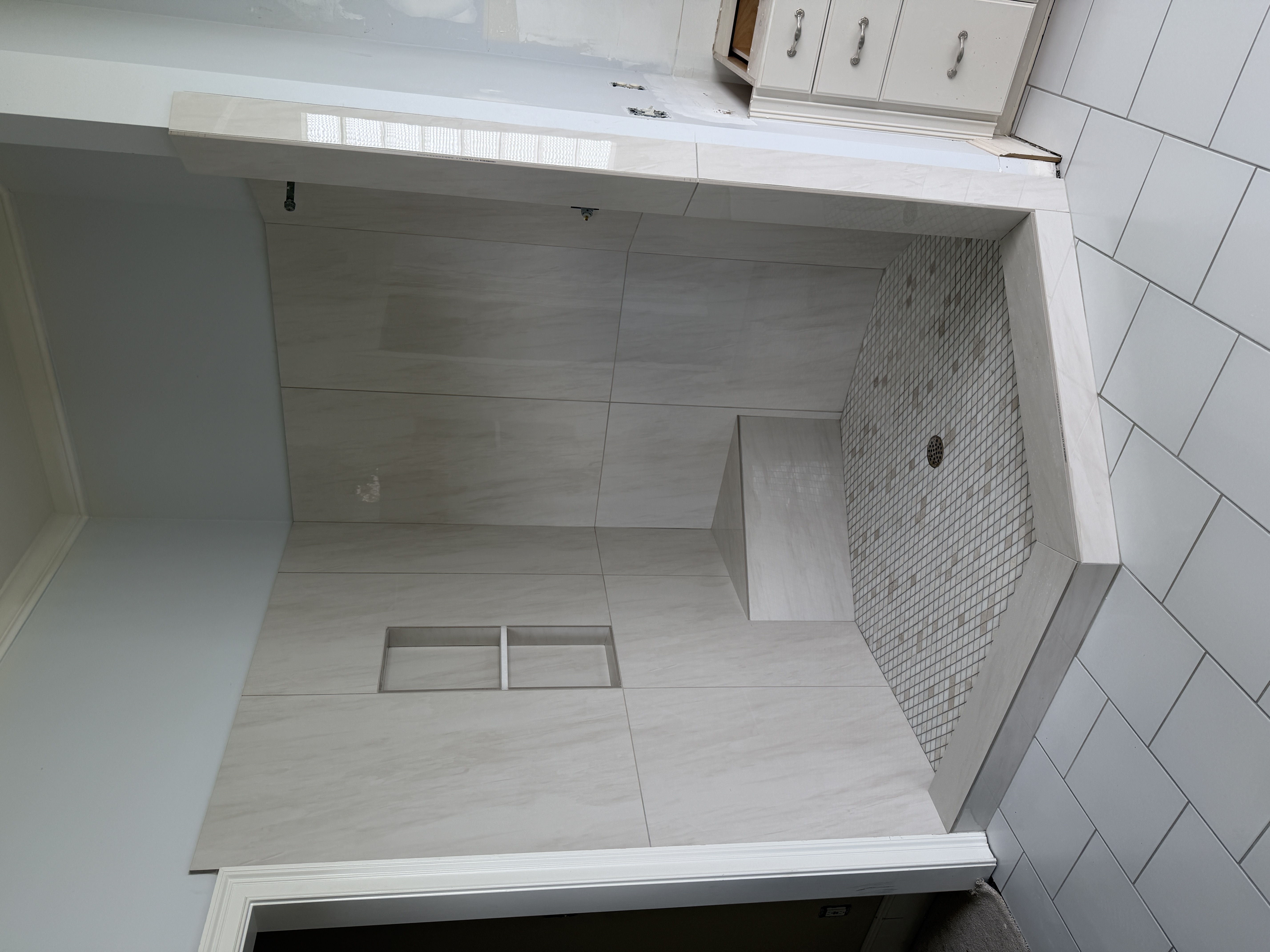 Large-format tiled shower with a bench